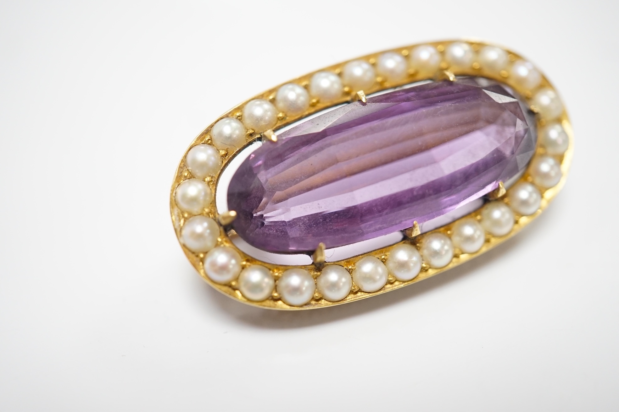 An early 20th century yellow metal mounted amethyst and split pearl cluster set oval brooch, 32mm, gross weight 8.8 grams. Condition - fair to good